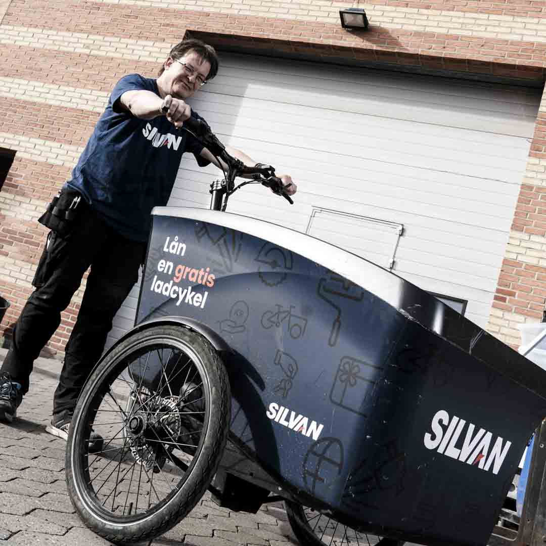 Medarbejder fra Silvan står med en ladcykel som kan lejes på Nørrebro.